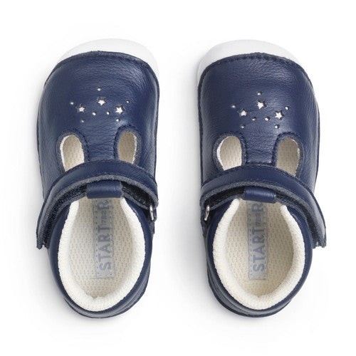 A pair of girls T-Bar pre walkers by Start-Rite, style Tumble, in navy leather with white sole, punch out star detail and velcro fastening. Above view.