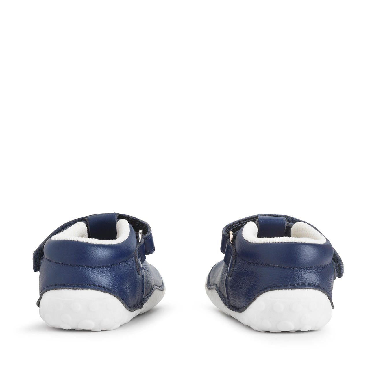 A pair of girls T-Bar pre walkers by Start-Rite, style Tumble, in navy leather with white sole, punch out star detail and velcro fastening. View from back of shoes.