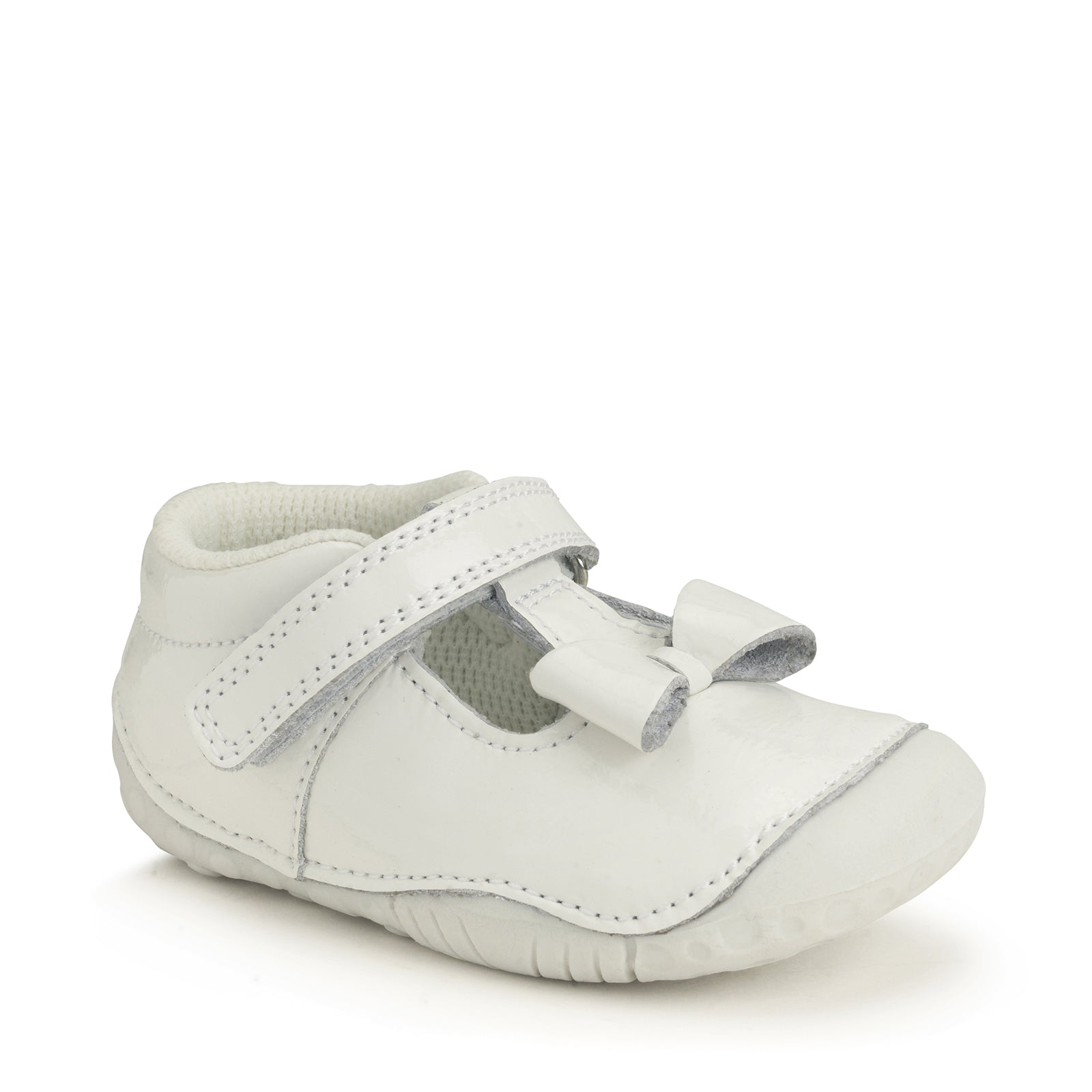 A girls pre-walker by Start-Rite, style Wiggle, with bow detail, in white patent leather. Toe bumper and velcro fastening. Angled view.