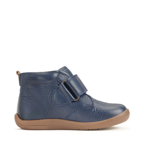 A boys ankle boot by Start-Rite, style Totter, in navy leather with light tan trim and sole unit. Velcro fastening. Left side view.