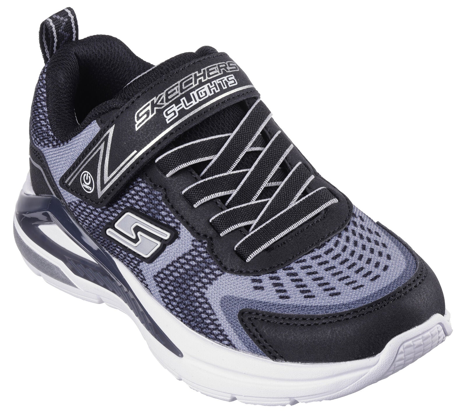 Skechers S Lights Tri-Namics, a boys light-up trainer in black with grey/black textile print, featuring Skechers branding. Velcro fastening with flat bungee laces. Top right angled view.