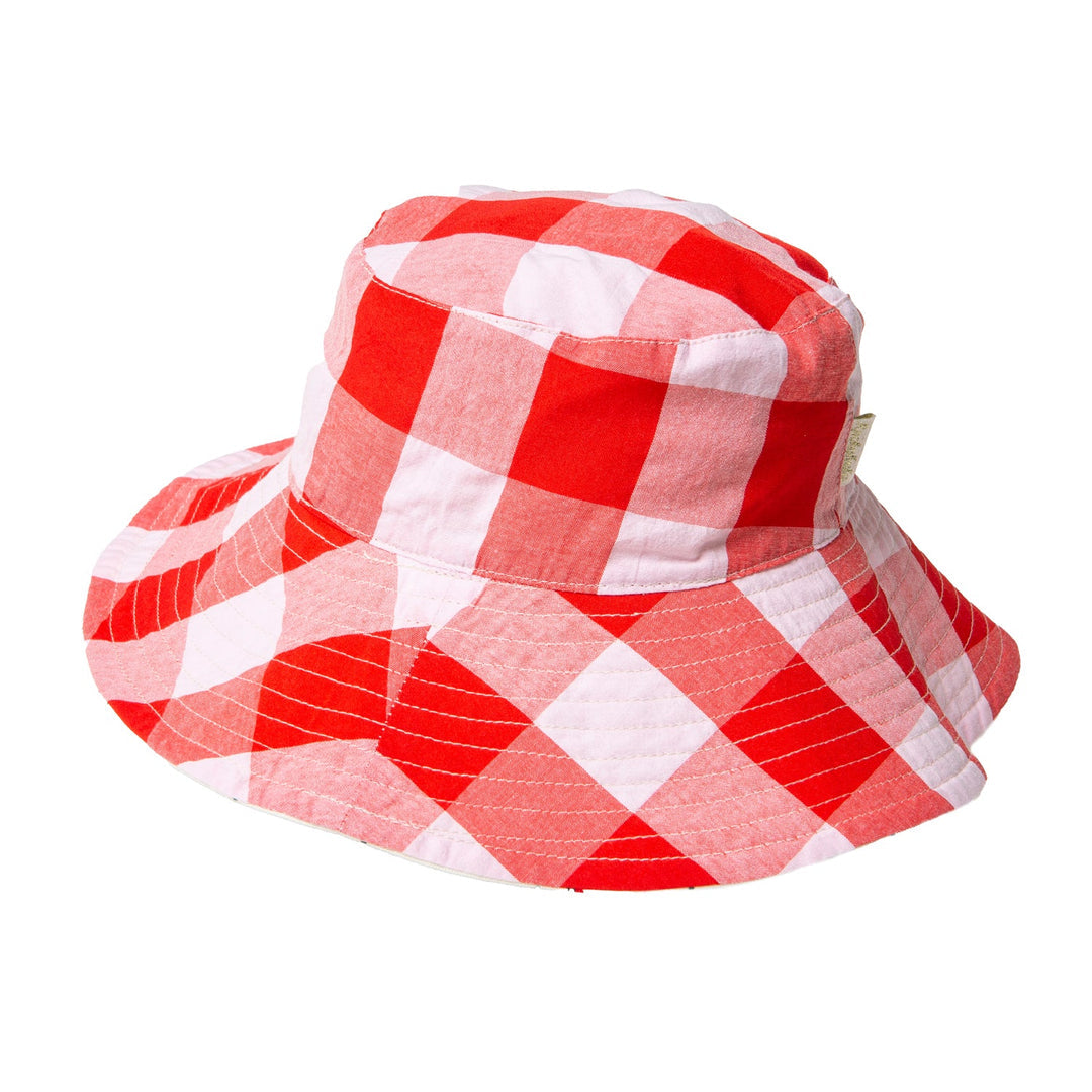 A reversible girls bucket hat by Rockahula, style Sweet Cherry, one side is white with red cherry print,the other red and white check. Front view.