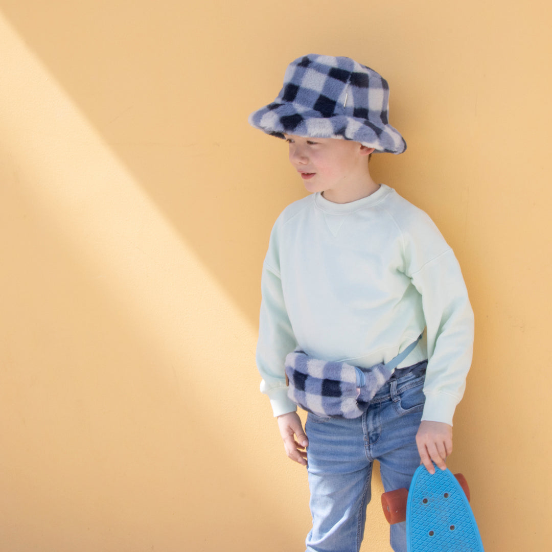 A bucket hat by Rockahula, style Furry Checked, in blue checked fur. Lifestyle image.