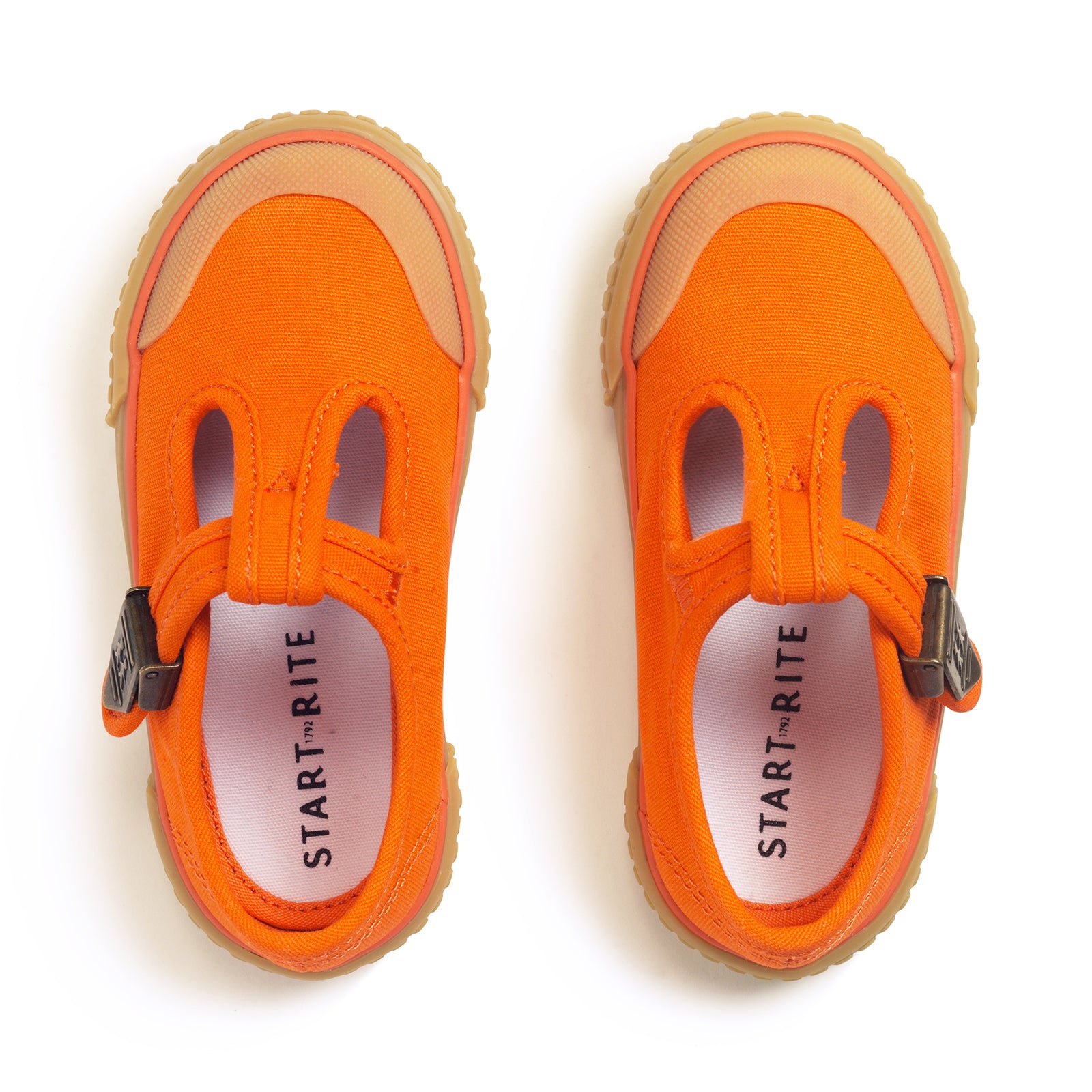 A pair of unisex canvas T-Bar shoes by Start-Rite, style Anchor, in orange, with beige sole and toe bumper and buckle fastening. Above View.