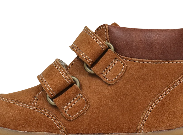 A boys ankle boot by Bobux, style Step Up Timber, in tan nubuck with brown leather trim amd double velcro fastening. Close up of straps.