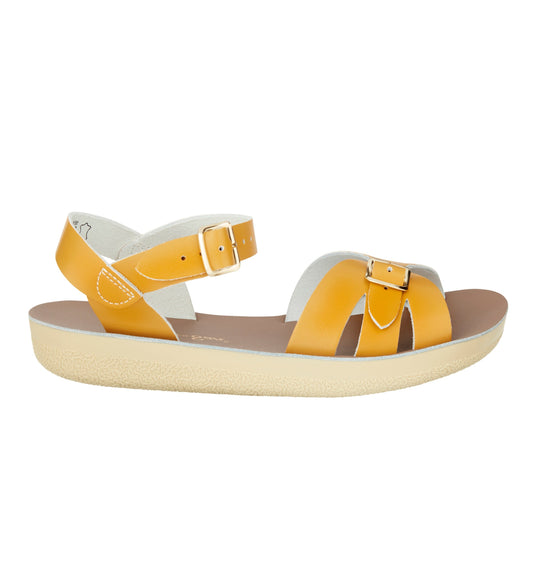 A Boardwalk style girls sandal by Salt Water Sandals in mustard with double buckle fastening across the toes and around the ankle. Open Toe and Sling-back. Right side view.