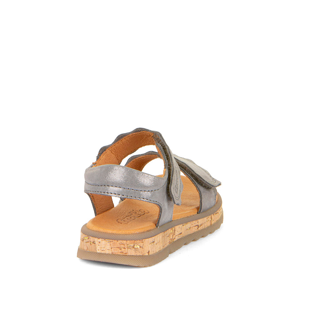 A girls open toe sandal by Froddo, style Alana G3150253-7, in silver leather set on cork effect sole unit with velcro fastening.  Angled view of back.