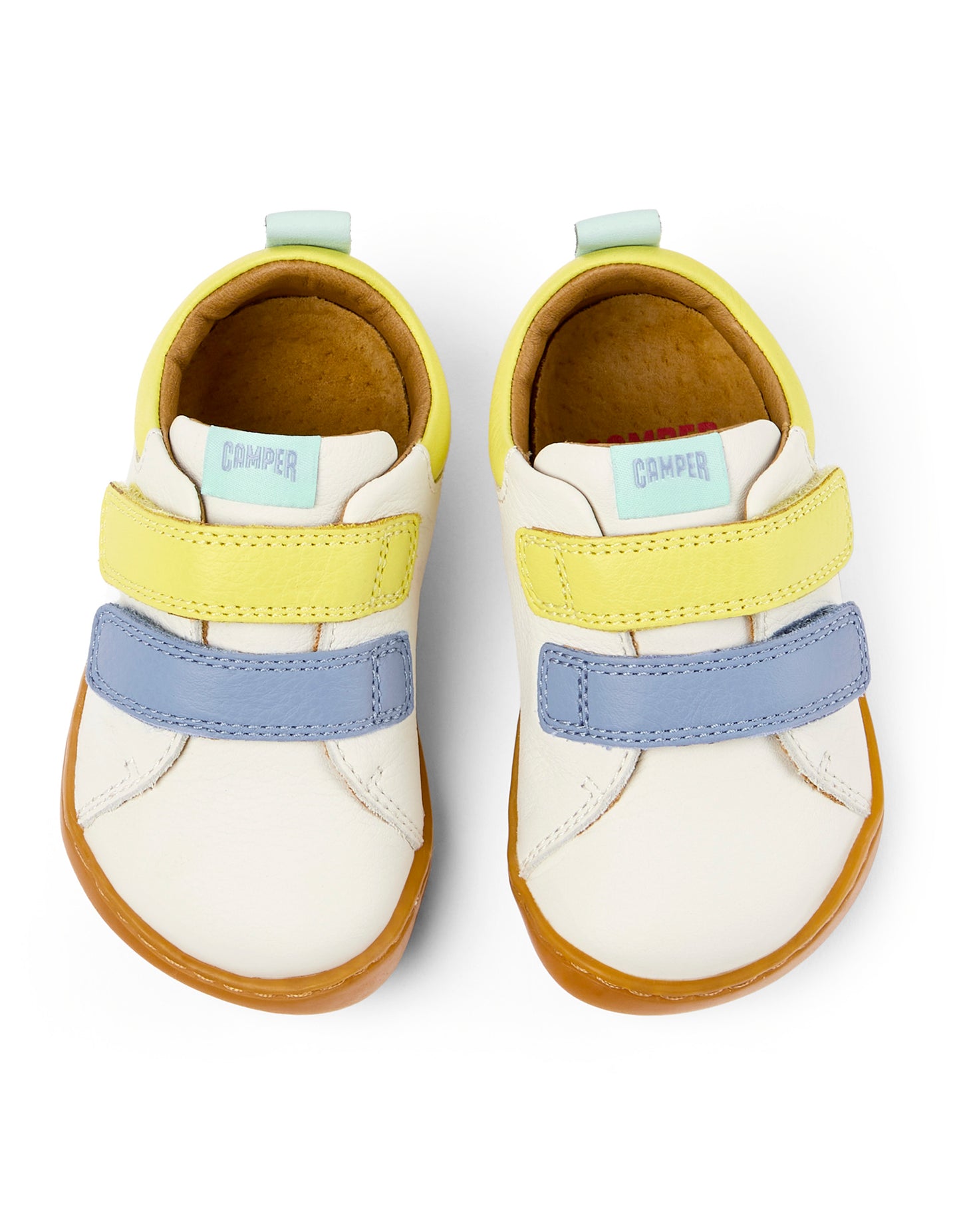 A unisex shoe by Camper, style Peu, in white with blue and yellow velcro straps. Above view of a pair.
