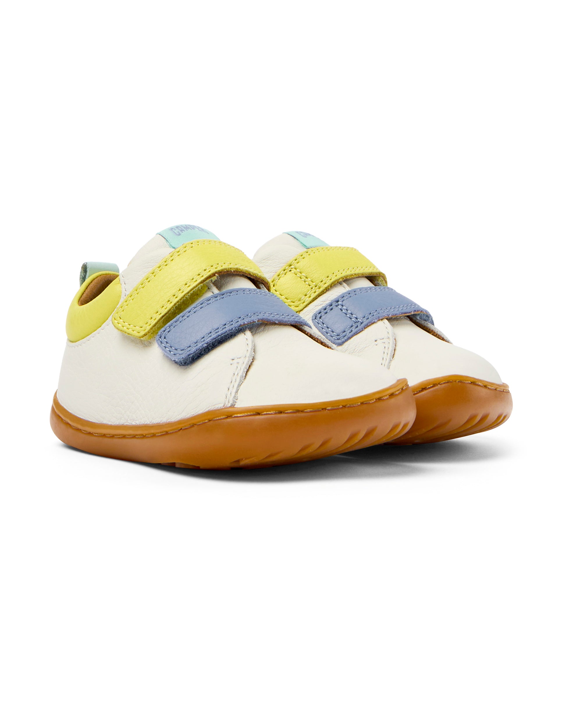 A unisex shoe by Camper, style Peu, in white with blue and yellow velcro straps. Angled view of a pair.