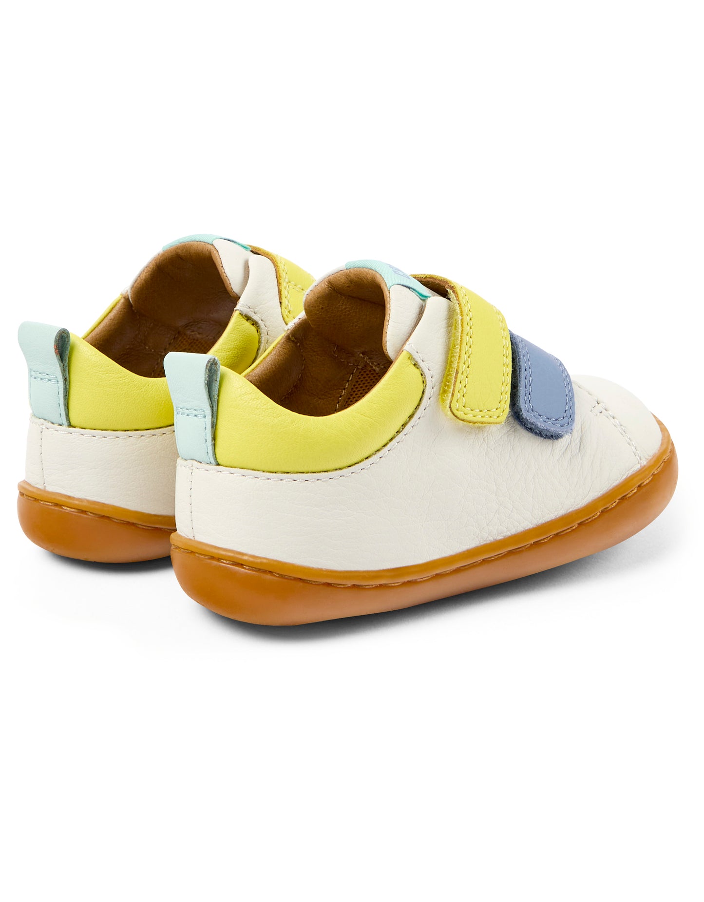 A unisex shoe by Camper, style Peu, in white with blue and yellow velcro straps. Rear side view of a pair.
