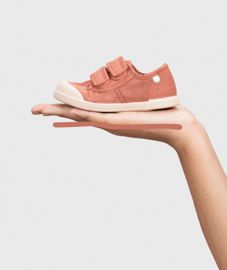 Igor Style Lona Velcro, a double velcro pump in terracotta with two velcro fastenings on a cream sole and a toe bumper. Moving image showing a female hand squishing the shoe.