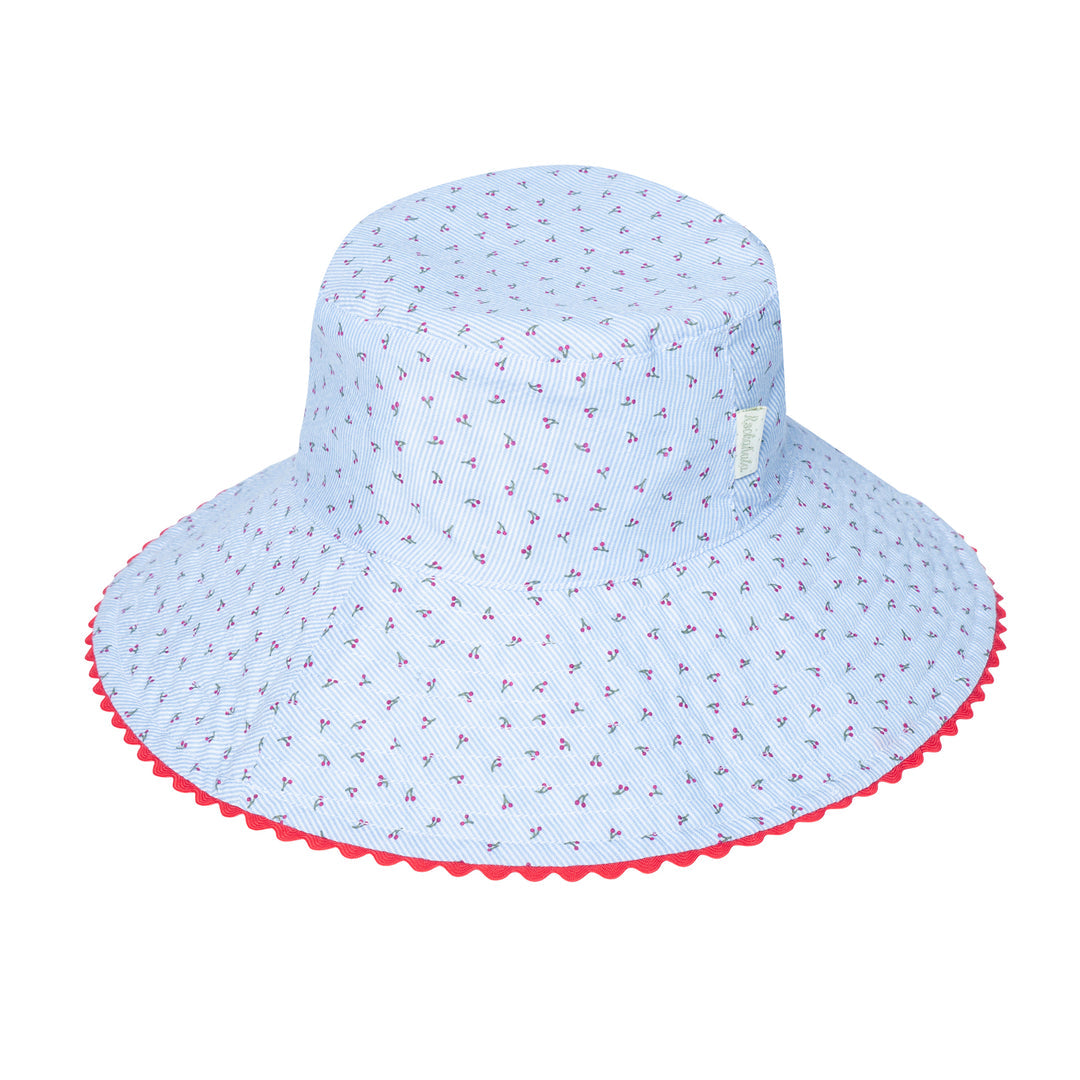 A reversible girls bucket hat by Rockahula, style Cherry Gingham,one side is blue and white stripe cherry print, the other blue and white gingham with cherry embroidery. Front view of cherry stripe side of hat.