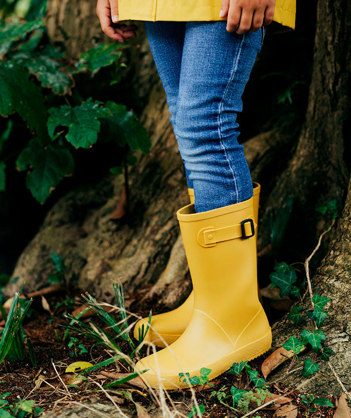 A unisex wellington boot by Igor. Style is Euri in yellow with side buckle adjuster. Lifestyle image.