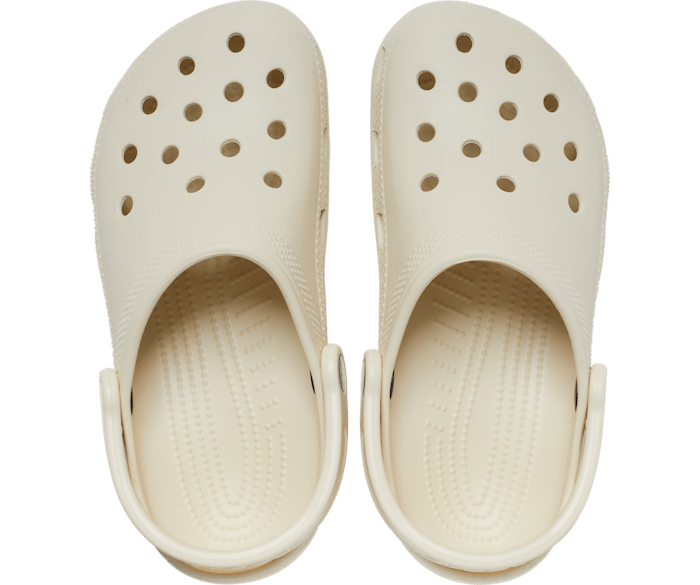 A unisex classic clog by Crocs, style Todd in bone. Above view of a pair.