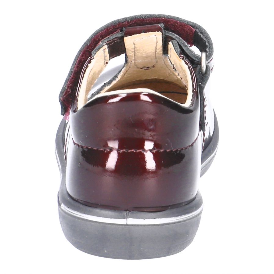 A girls T Bar shoe by Ricosta, style Winona, in Bordo patent with velcro fastening. Back view.