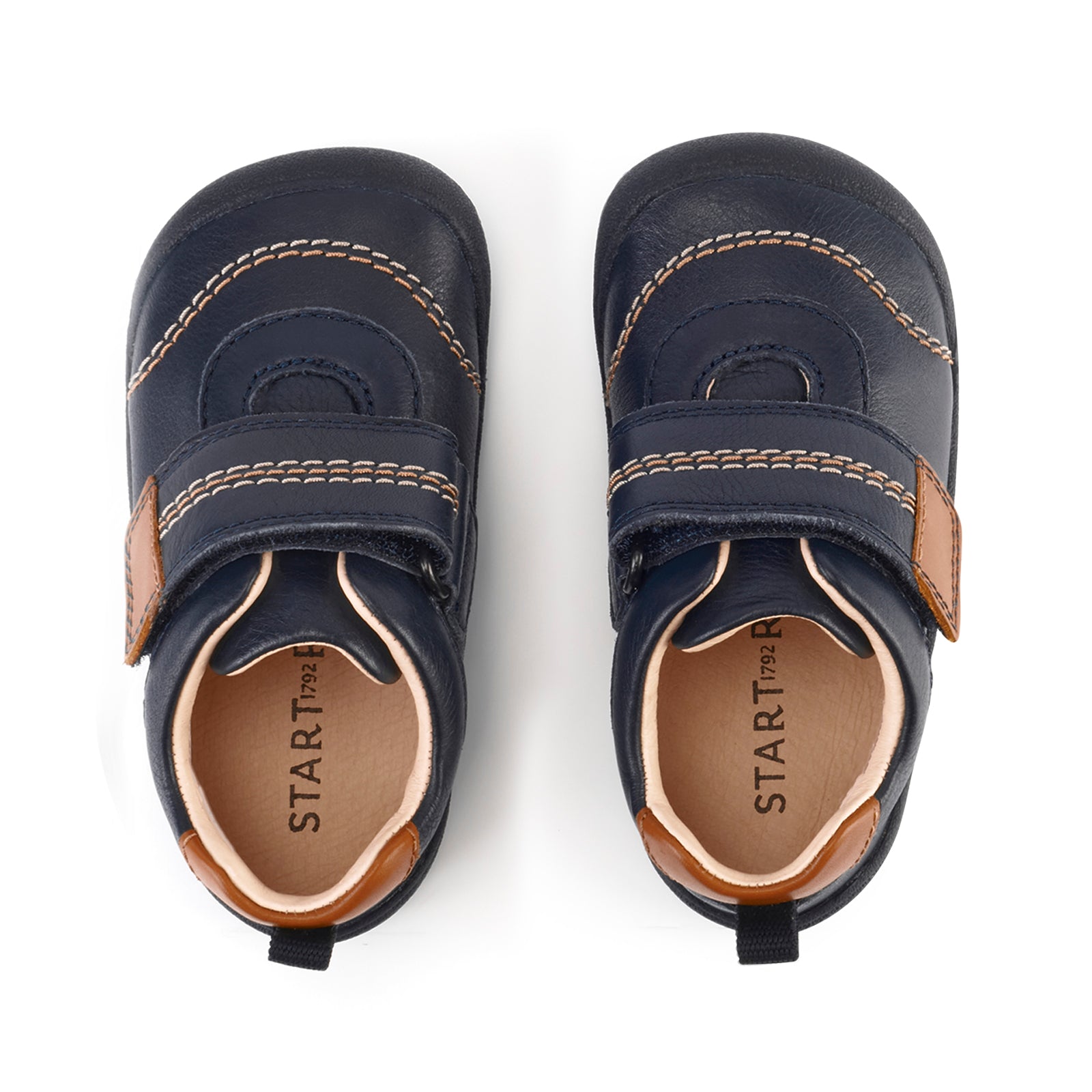 A boys first shoe by Start-Rite, style Footprint, in navy with tan trim and stitch detailing, velcro fastening. Above view of a pair.