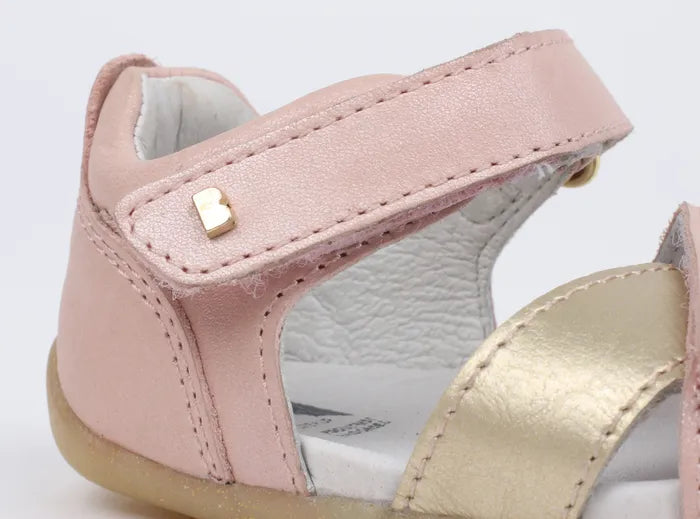 A girls open toe sandal by Bobux, style Sail, in pink and gold with velcro fastening. Close up view.