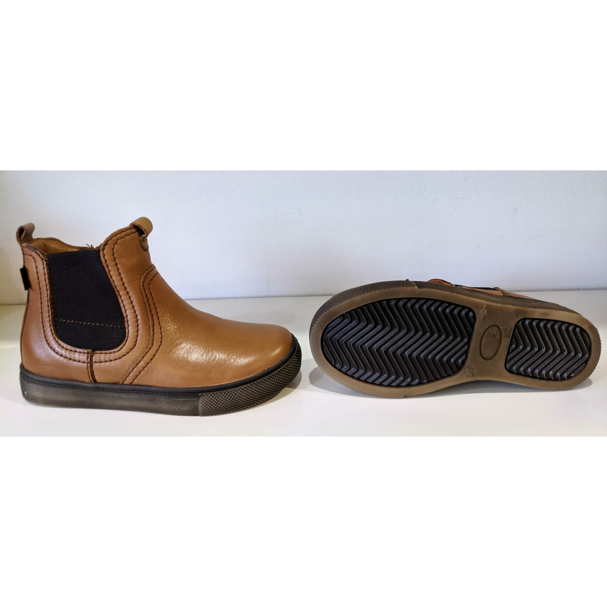 A boys waterproof Chelsea boot by Froddo, style Tomy Tex G3160146-2,in tan leather with zip fastening. View of right side and sole of a pair.