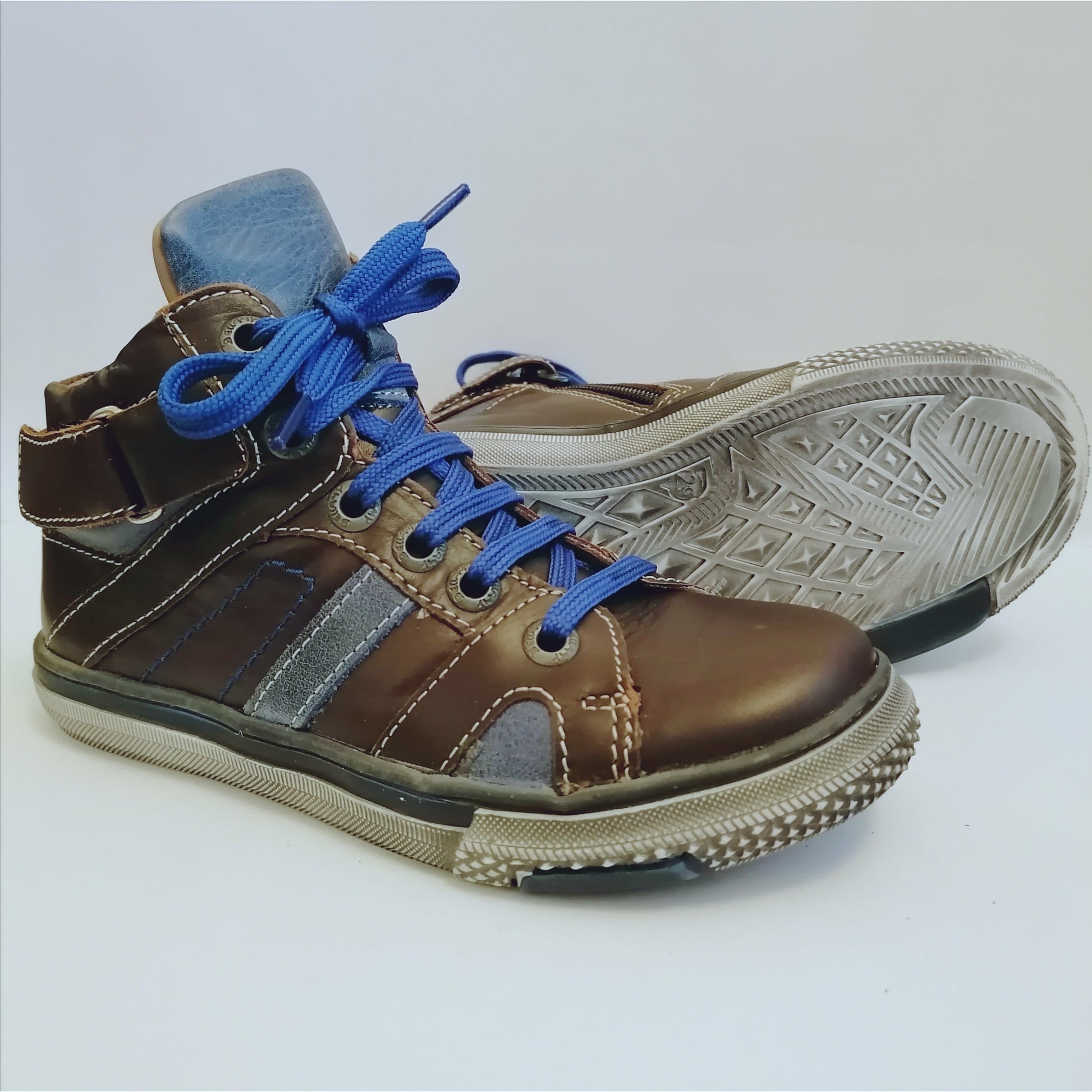 A boys boot by Bellamy, style Twix, dark brown and blue with lace and zip fastening. Right side view, left view of distressed sole.