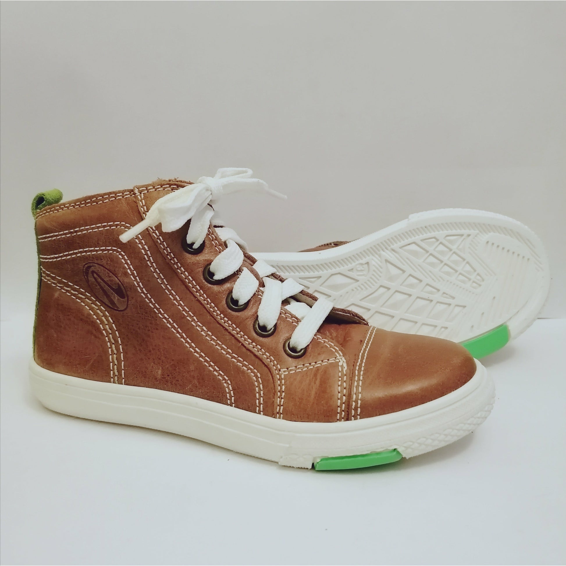 A high top boot by Richter, tan leather, with contrast white laces and stitching, inside zip fastening. Right side view, left view of white sole.