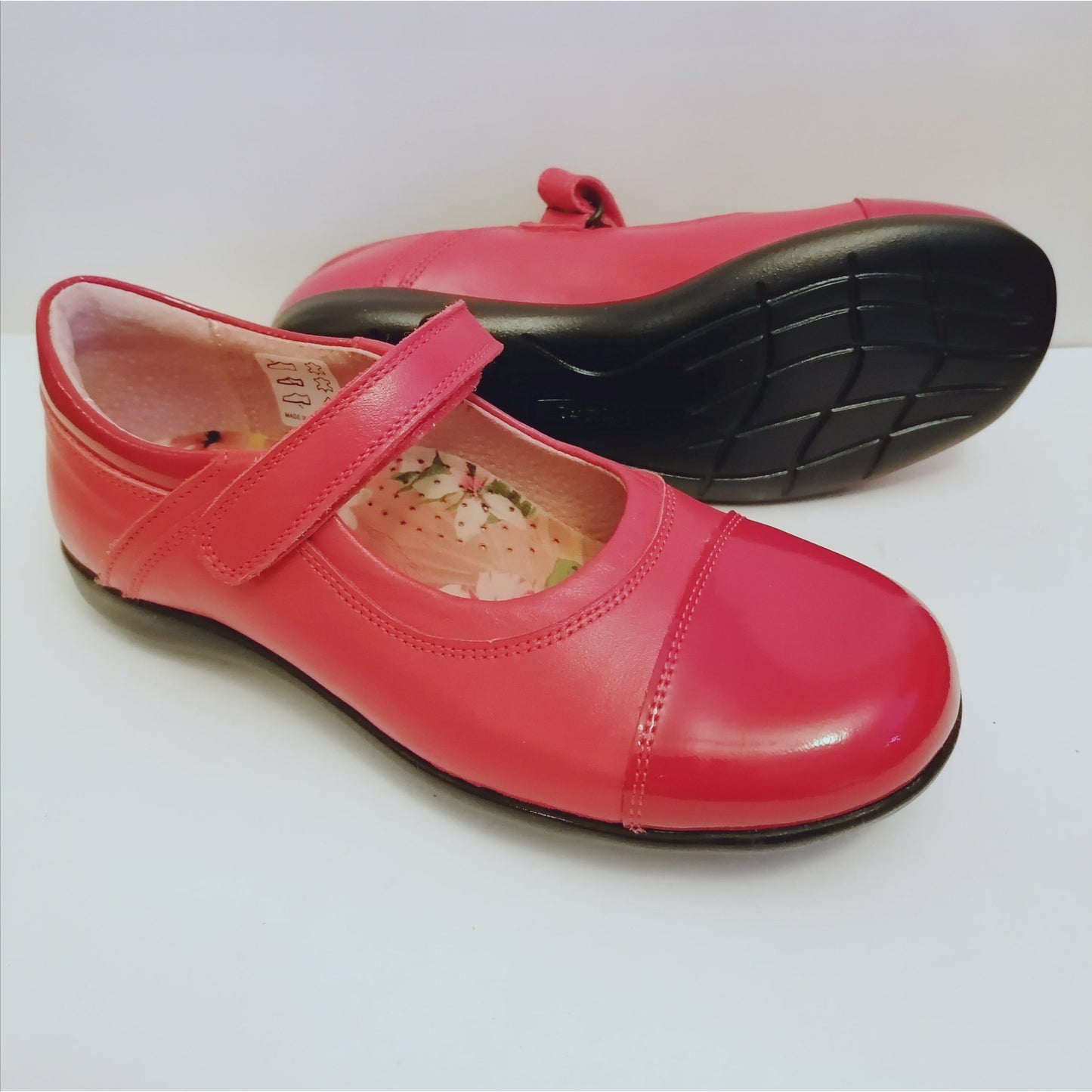 A girls shoe by Petasil, style Becky, velcro fastening in red leather with a patent toe and collar. Right side view, left view of black sole.