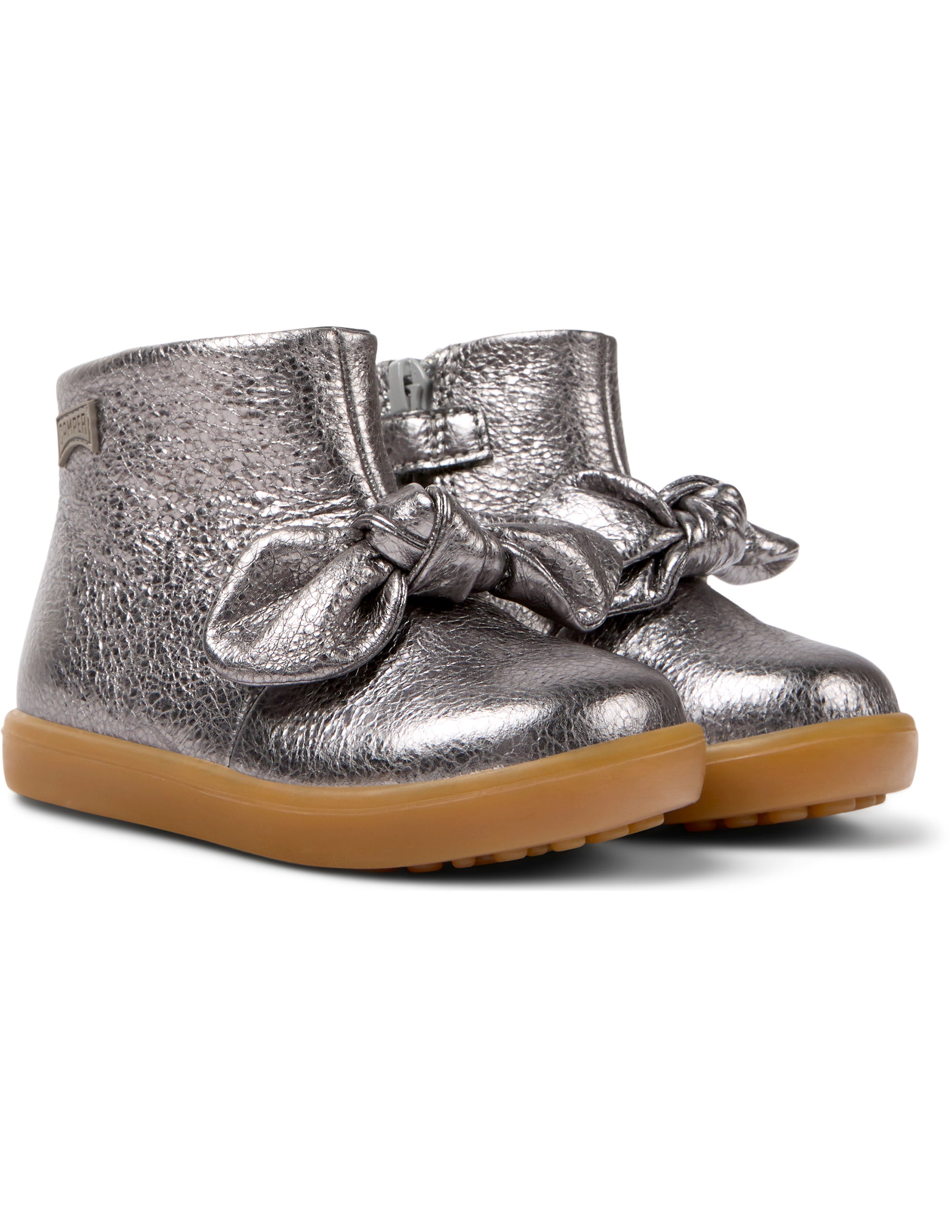 A pair of girls ankle boots by Camper, style K900267-006 in dark silver with bow front and zip fastening. Angled view.,